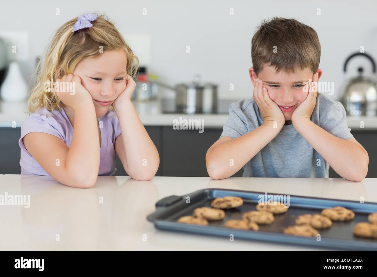 Bruder und Schwester verlockend Cookies betrachten Stockfoto