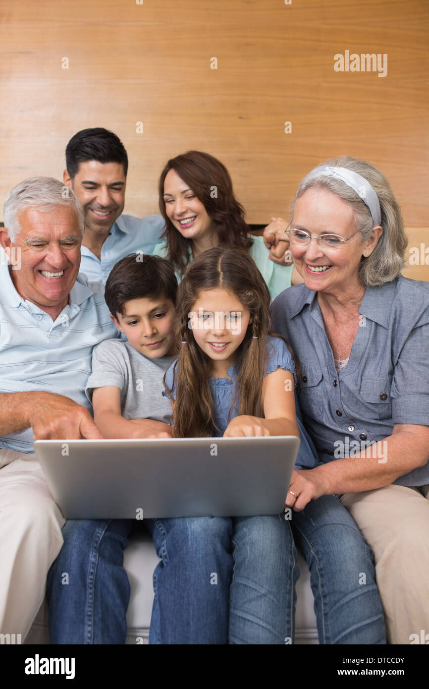 Großfamilie mit Laptop auf dem Sofa im Wohnzimmer Stockfoto