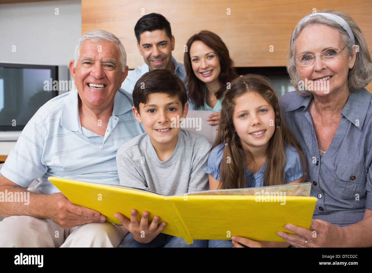 Porträt einer Großfamilie mit Blick auf deren Album Foto Stockfoto