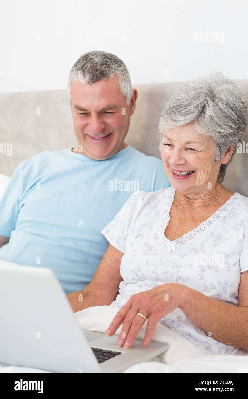 Älteres Paar mit Laptop-Computer im Bett Stockfoto