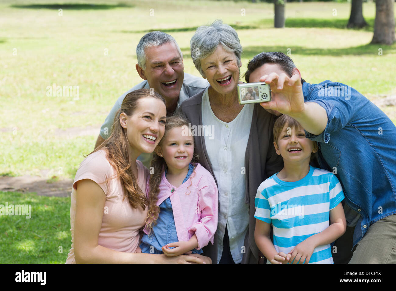 Mann unter Bild der Großfamilie im park Stockfoto