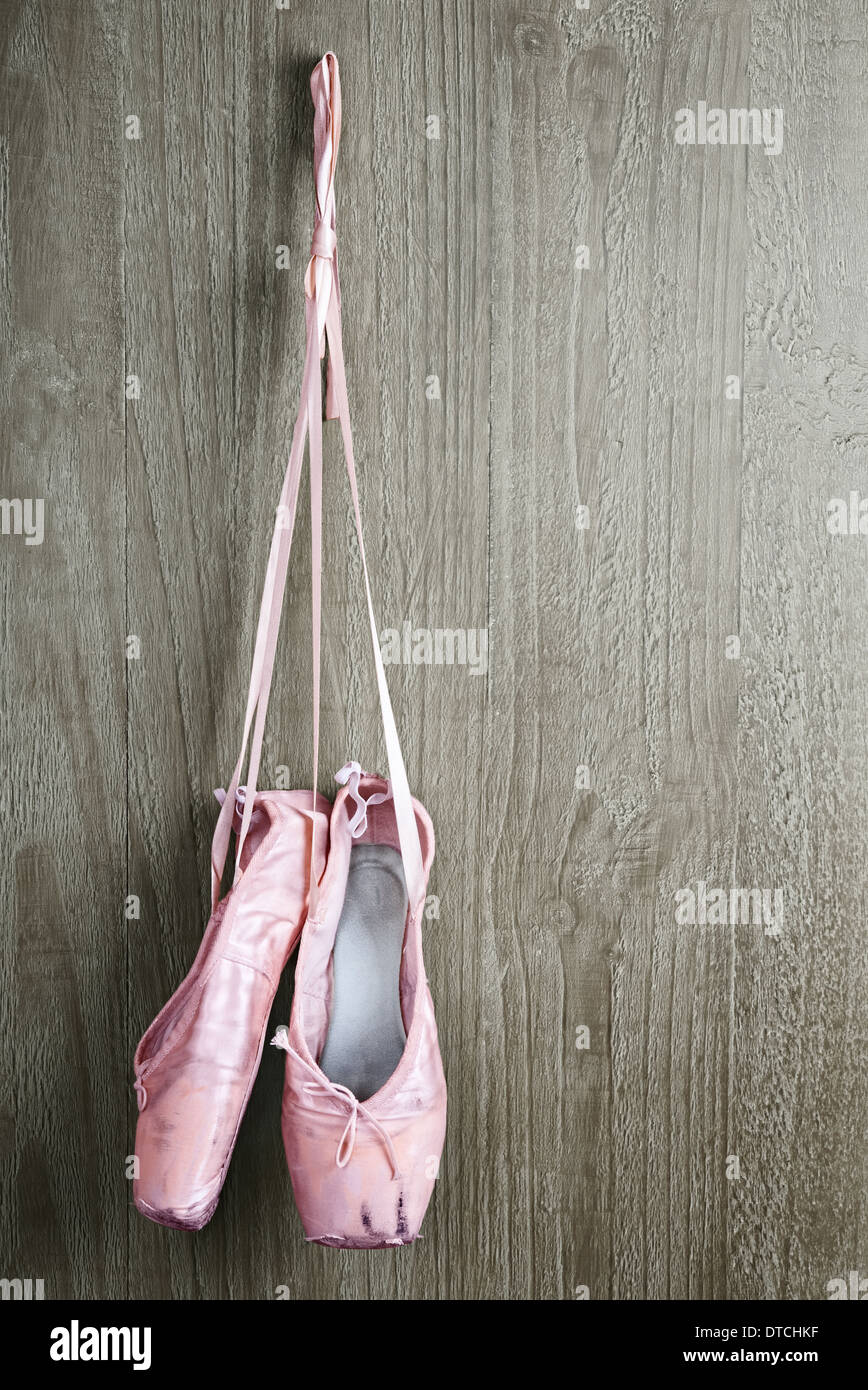 Alten verwendet rosa Ballettschuhe hängen hölzerne Hintergrund Stockfoto