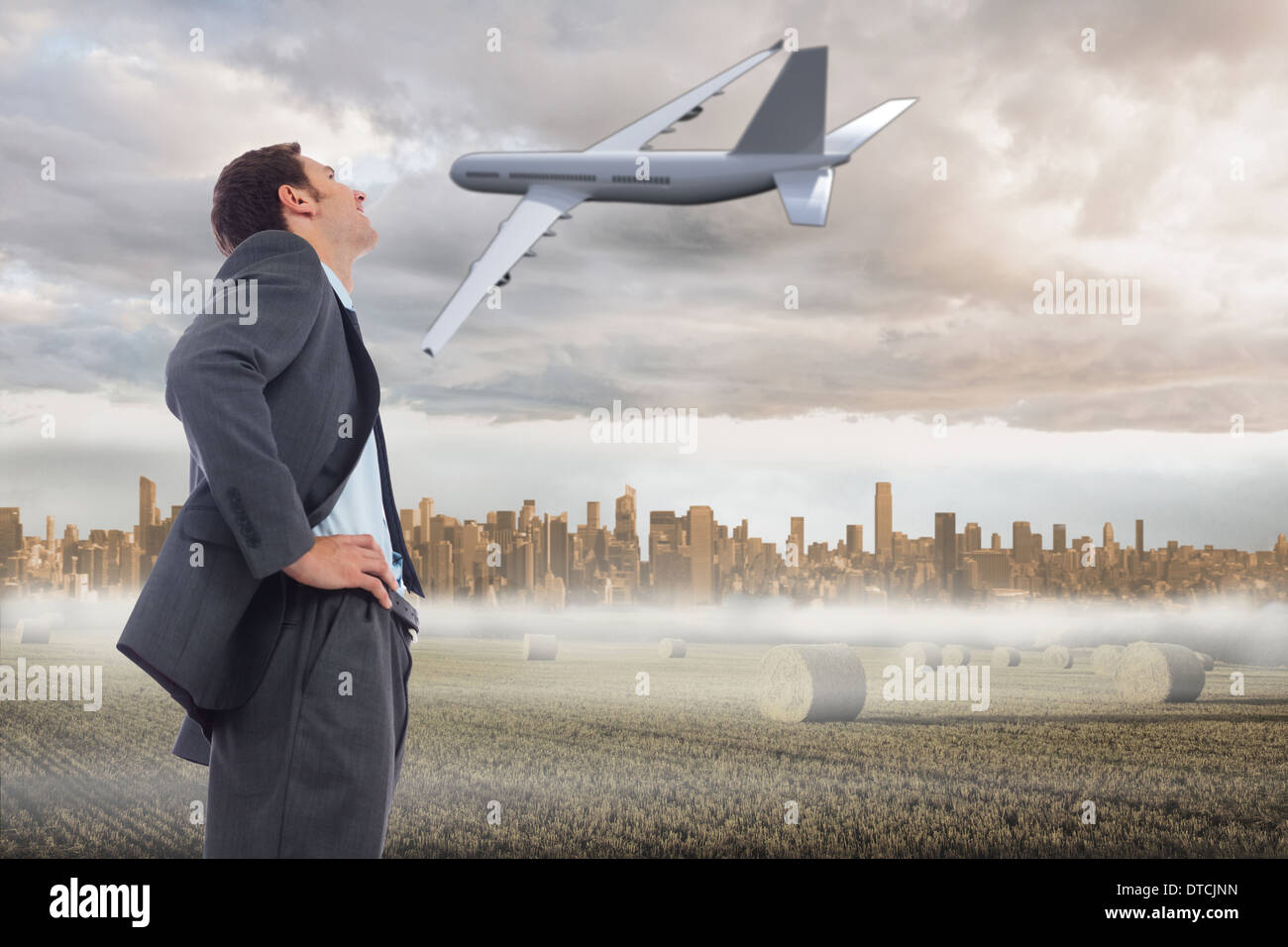 Zusammengesetztes Bild von fröhlich Geschäftsmann stehend mit Händen auf den Hüften Stockfoto