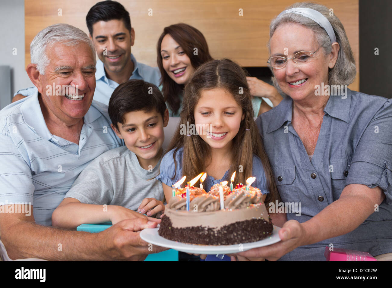 Großfamilie mit Kuchen im Wohnzimmer Stockfoto