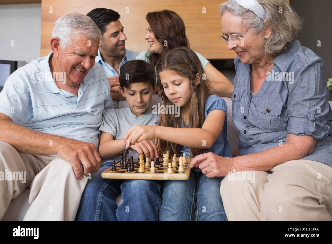 Glückliche Großfamilie Schachspielen im Wohnzimmer Stockfoto