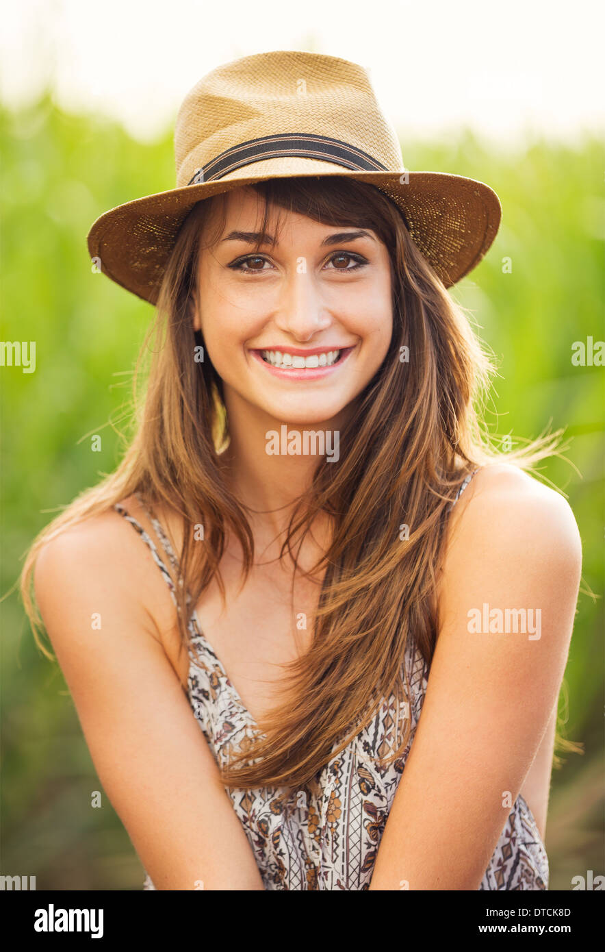 Schöne junge Frau im Freien. Romantische Mode-Lifestyle-Modell im Sonnenkleid. Glückliche Gefühle. Hintergrundbeleuchtung. Warme Farbtöne Stockfoto