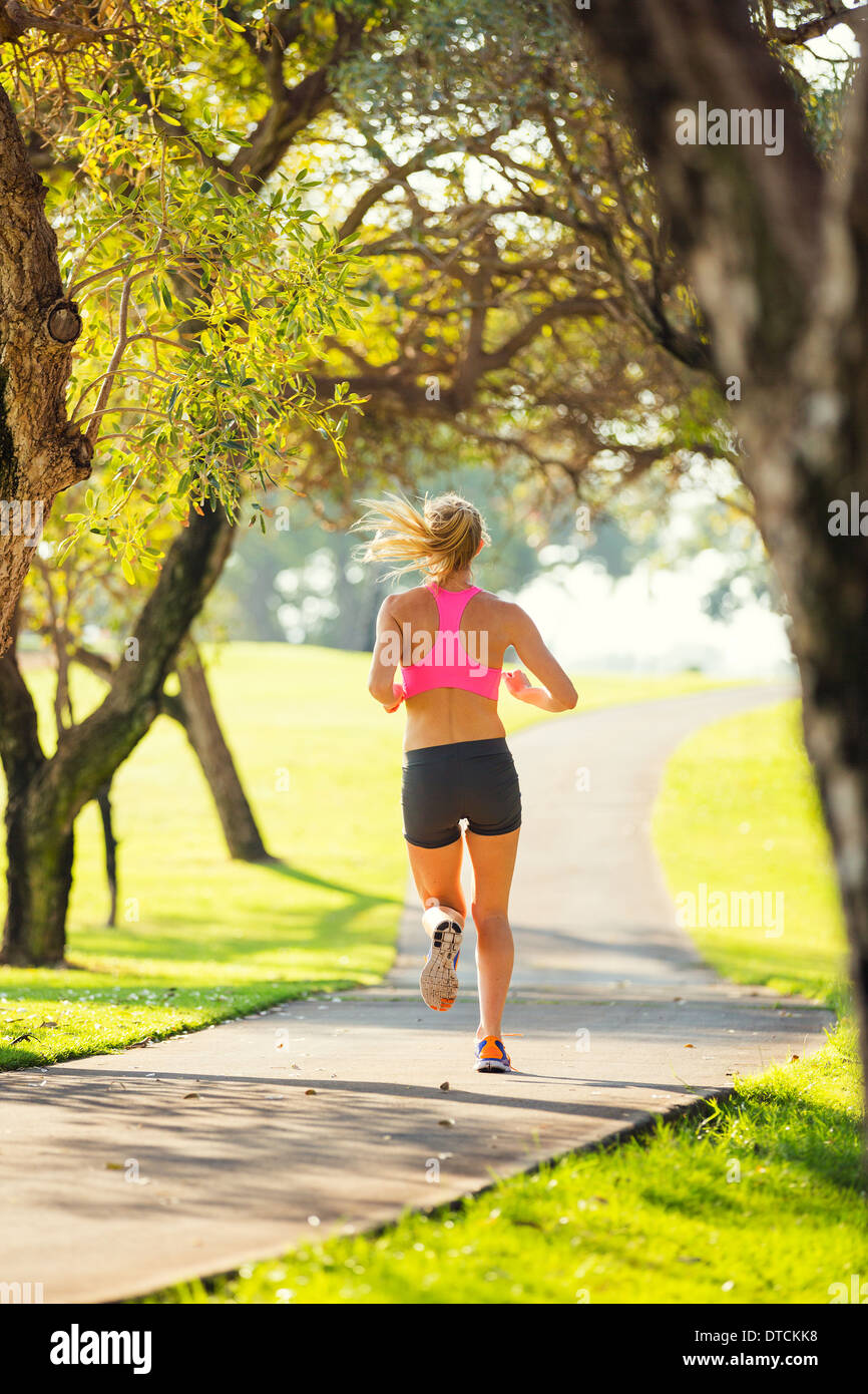 Attraktive junge Frau, Joggen im Park Trail in den frühen Morgenstunden. Gesunder Lifestyle Fitness Running-Konzept Stockfoto