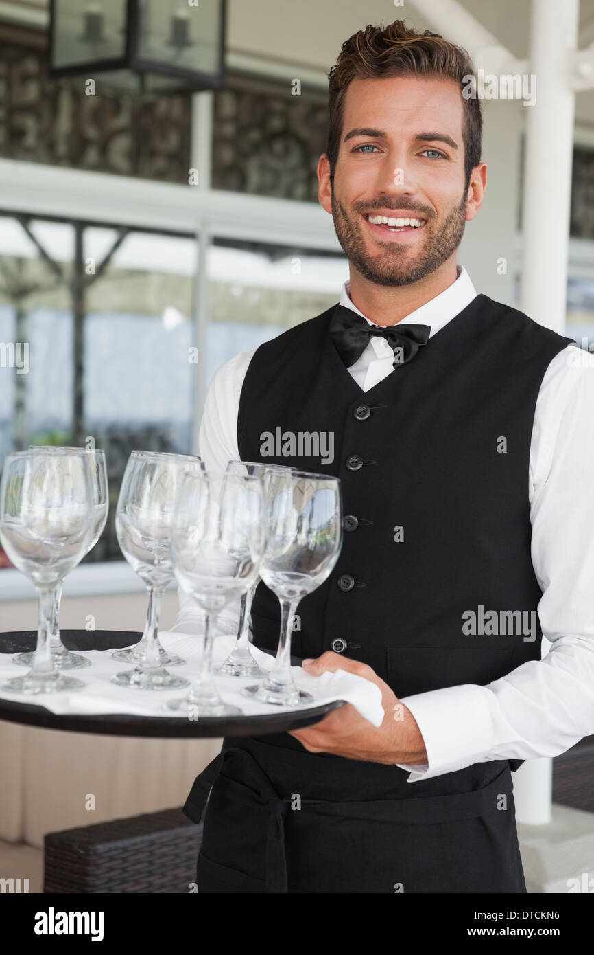 Hübscher Kellner mit Tablett mit Weingläser Stockfoto