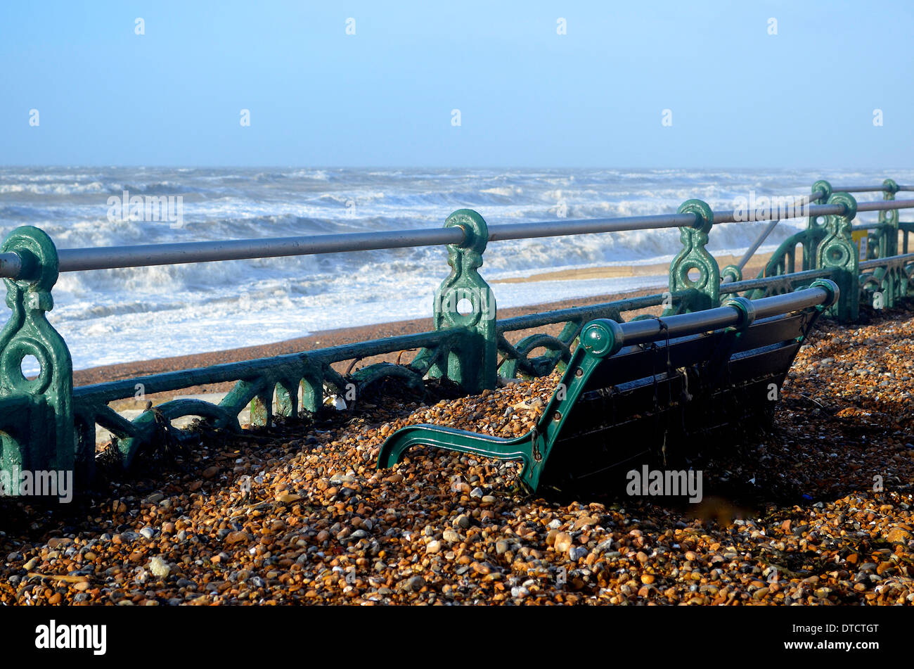 Brighton hove seafront Promenade Promenade winter storm Kieselsteine Geländer Strandhütten Sitzbank Bänke Wellen über Weg Stockfoto