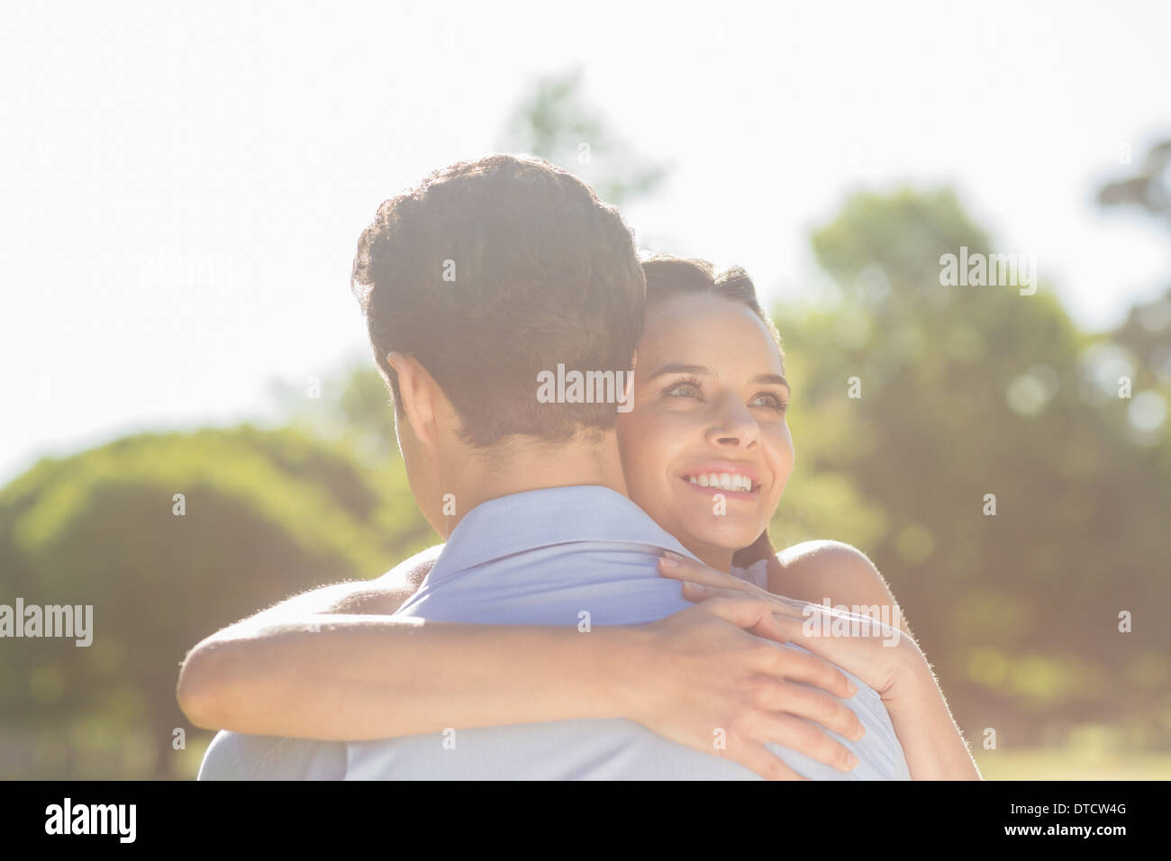 Liebevolle und glückliche Frau umarmen Mann im park Stockfoto