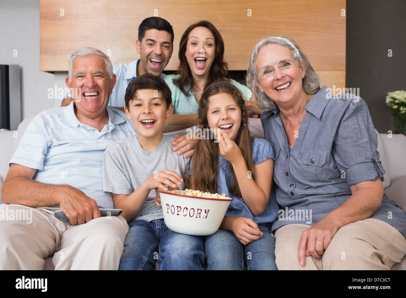 Porträt der glückliche Familie vor dem Fernseher im Wohnzimmer Stockfoto