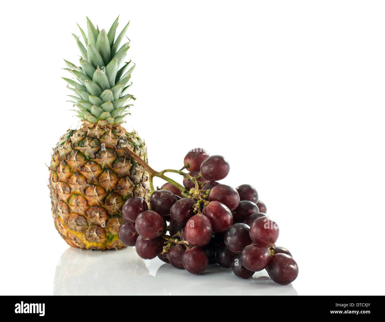 Ananas und roten Trauben isoliert auf weiss Stockfoto