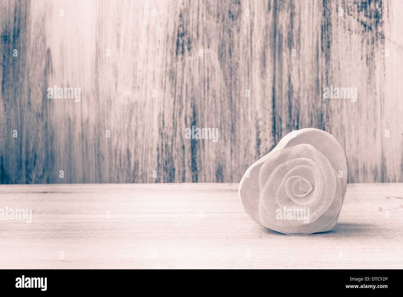 Weißes Herz mit Rose auf weißem Holz Hintergrund Stockfoto