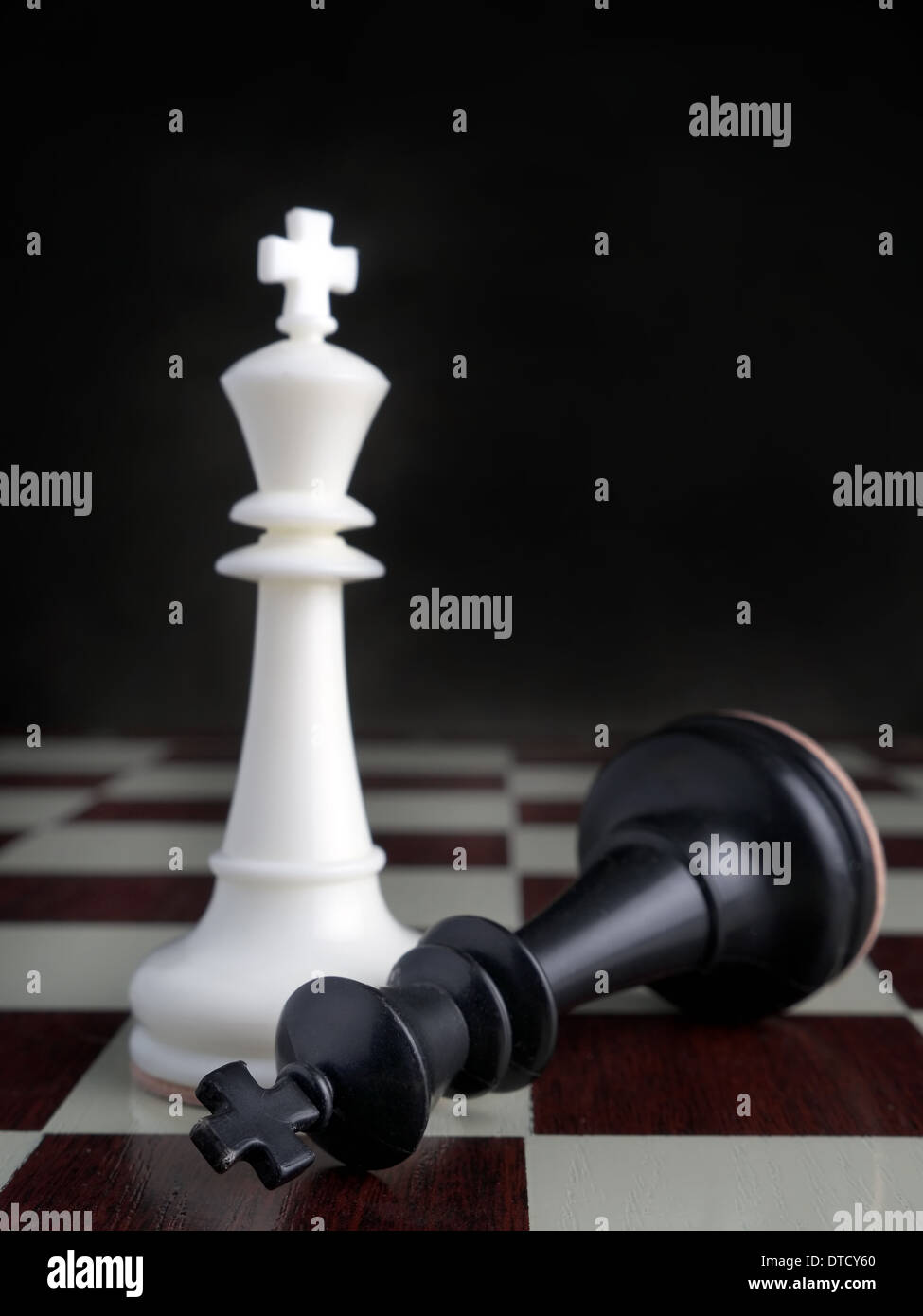 Schwarzen König auf Schachbrett von den preisgekrönten weißen König liegend Stockfoto