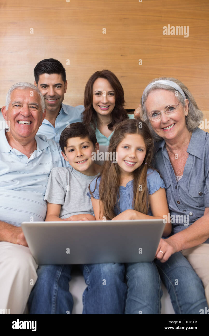 Großfamilie mit Laptop auf dem Sofa im Wohnzimmer Stockfoto