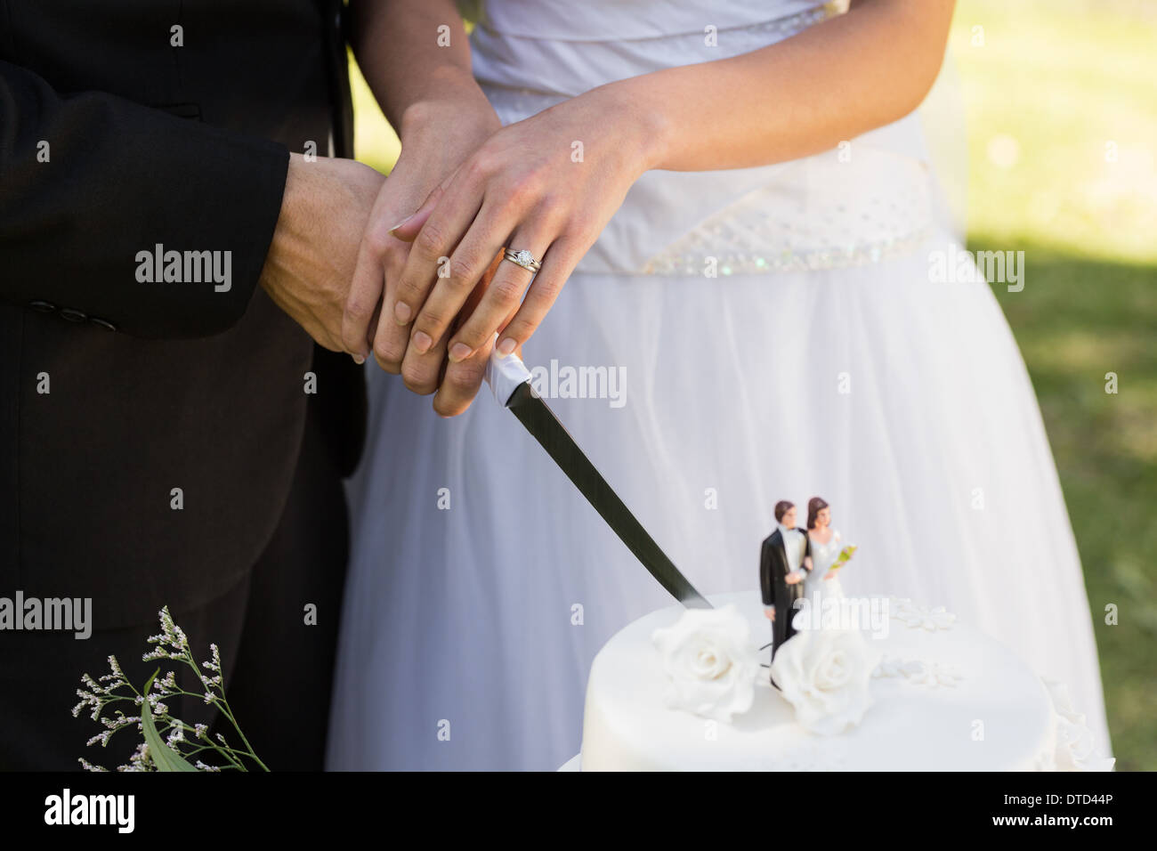 Mittleren Bereich der Frischvermählten schneiden Hochzeitstorte Stockfoto