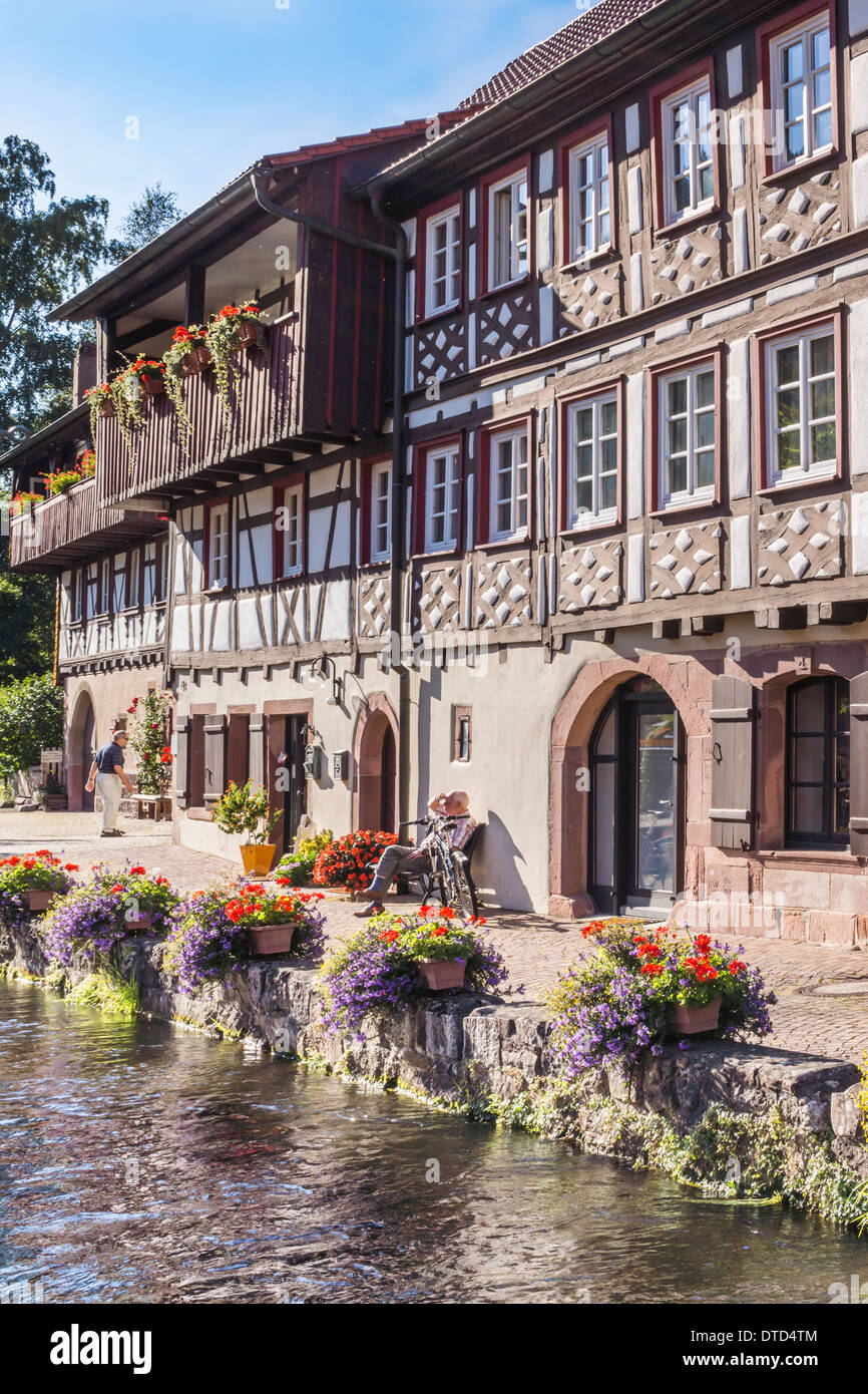 Fachwerkhaus am Ufer einer Blume geschmückt Creek in der Altstadt von Schiltach, Schwarzwald, Baden-Württemberg Stockfoto