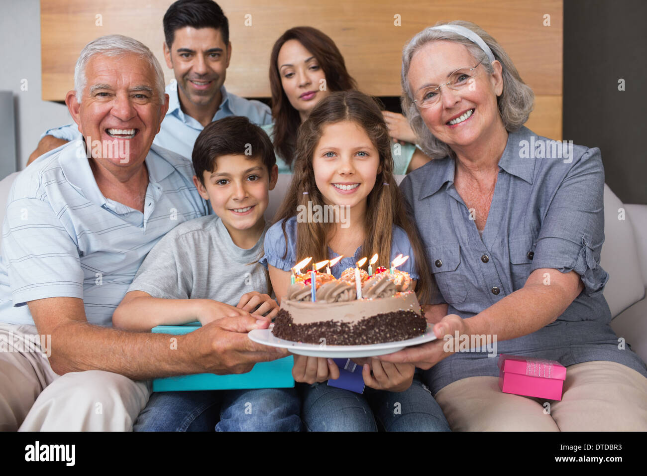Porträt der Großfamilie mit Kuchen im Wohnzimmer Stockfoto