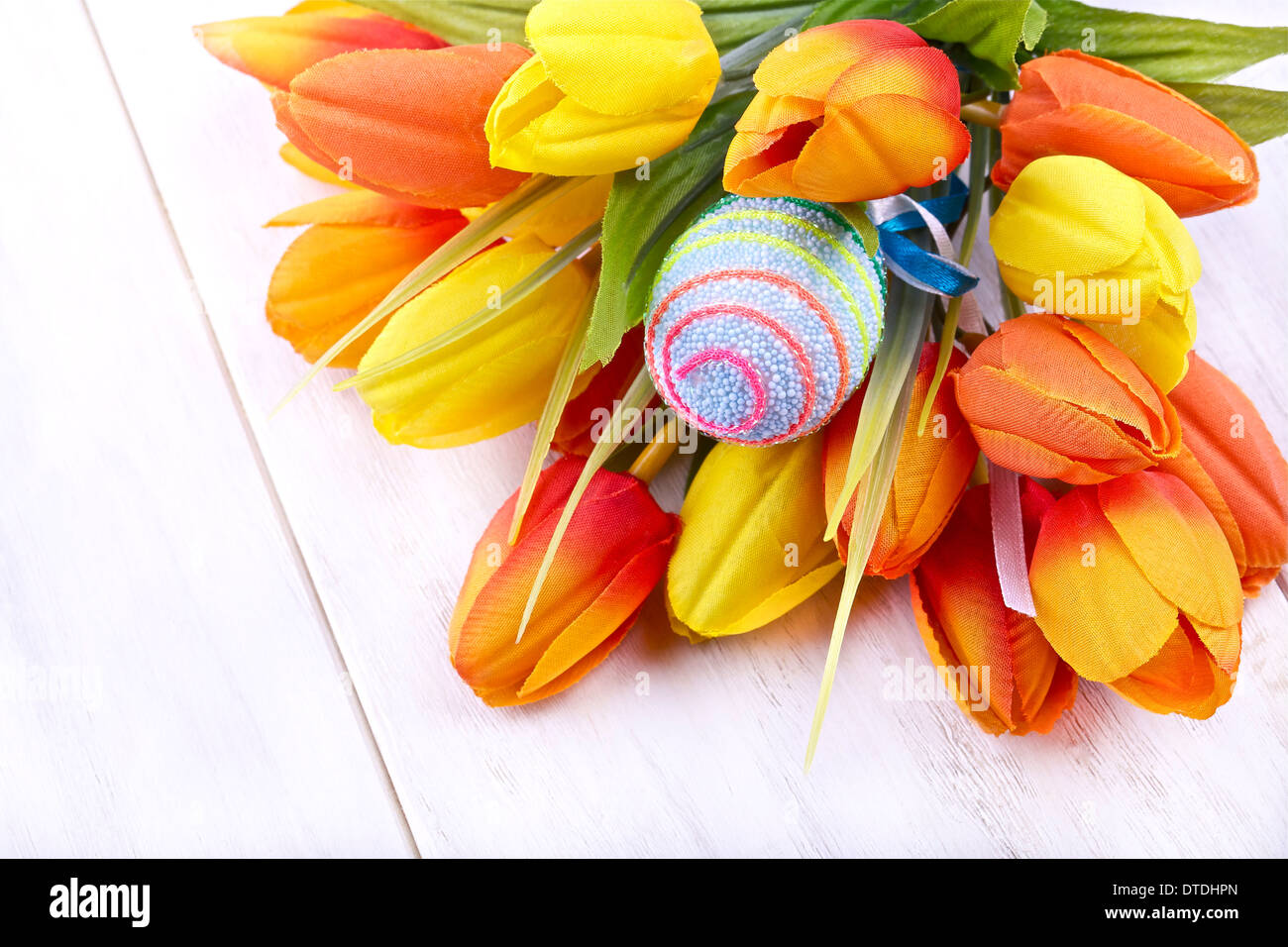 Osterei und Tulpen auf hellem Hintergrund Stockfoto