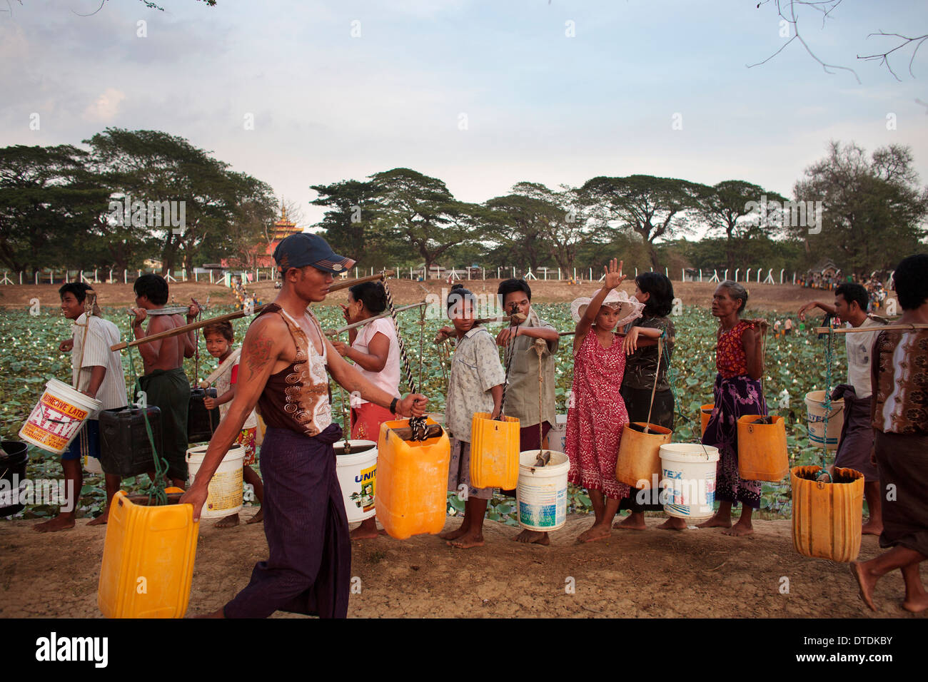 Ein Mann füllen Sie Behälter mit Wasser in einem kleinen See in Dala Township, Myanmar, Montag, 6. Mai 2013. Stockfoto