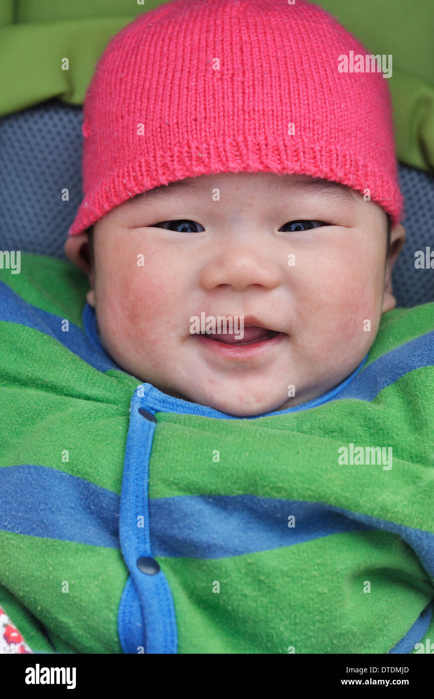 glückliches Baby in einem Kinderwagen, 6 Monate alt, Chinesisch Stockfoto