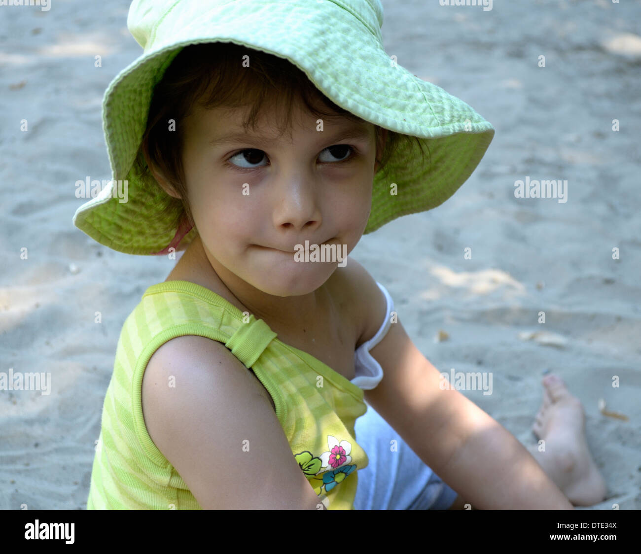 Kleines Mädchen mit grünem Hut machen Sie ein Gesicht Stockfoto