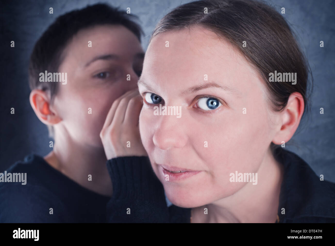 Zwei Frauen tratschen, Geheimnisse oder Hörensagen Geschichten zueinander zu sagen. Stockfoto