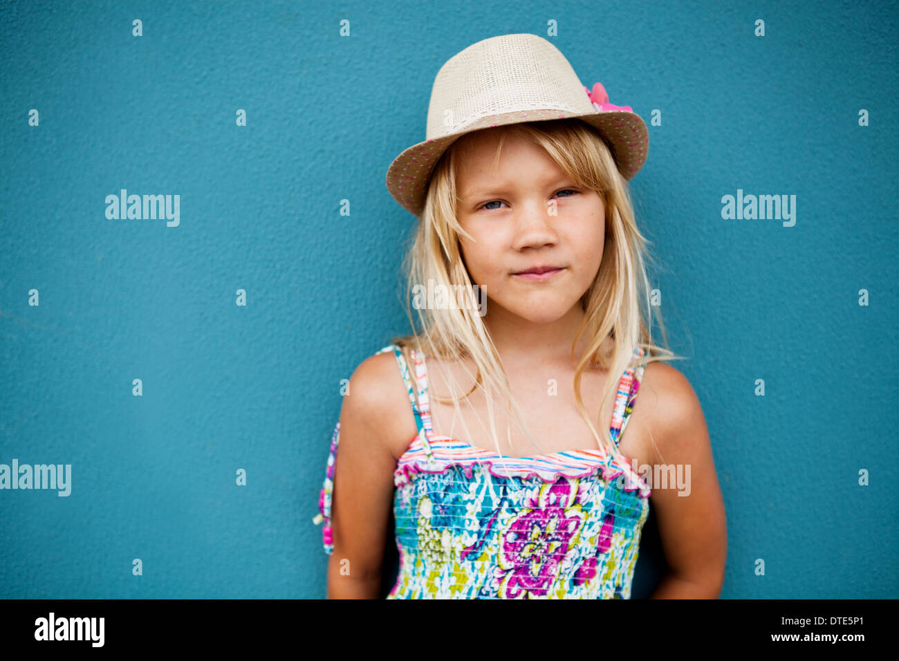 Porträt von netten jungen Mädchen in entspannter Haltung stylischen Hut außerhalb Hintergrund blaue Wand Stockfoto