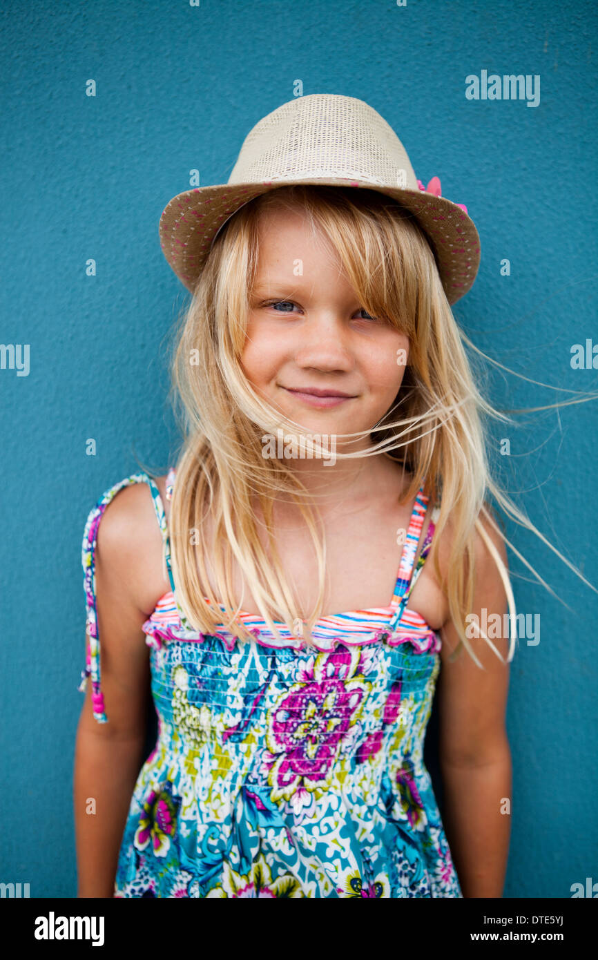 Porträt süß fröhliches junges Mädchen mit stilvollen Hut außerhalb Hintergrund blaue Wand Stockfoto