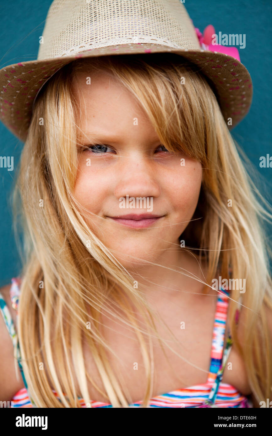 Closeup Portrait der niedliche junge Mädchen mit stylischen Hut außerhalb Hintergrund blaue Wand Stockfoto