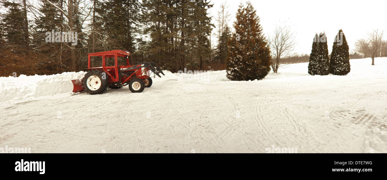 Alten Traktor und und Schnee in einem ländlichen Hof gelöscht Stockfoto