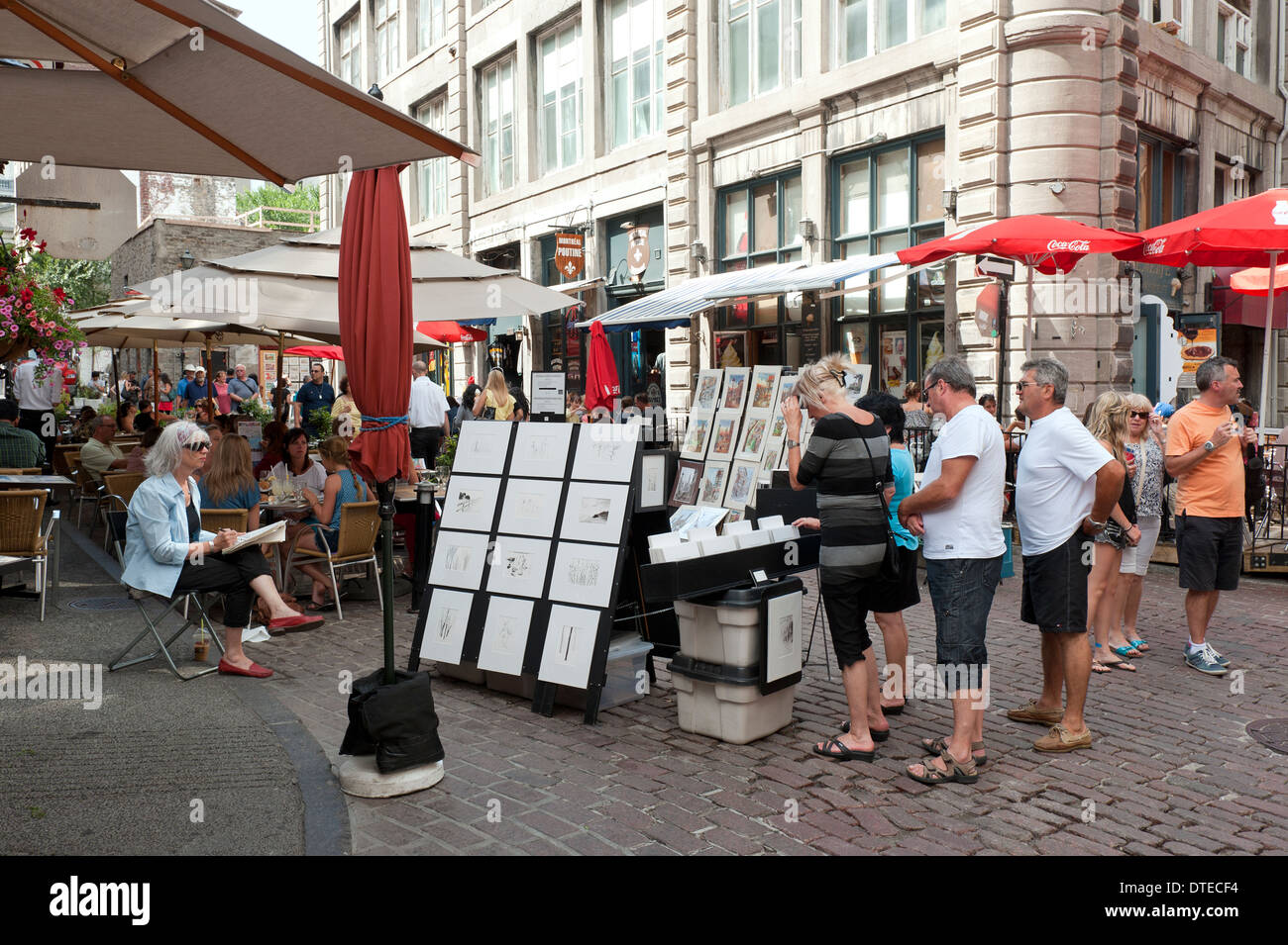 Besucher betrachten Drucke in Aufmachungen für den Verkauf von einem Künstler in Old Montreal, Québec, Kanada. Stockfoto