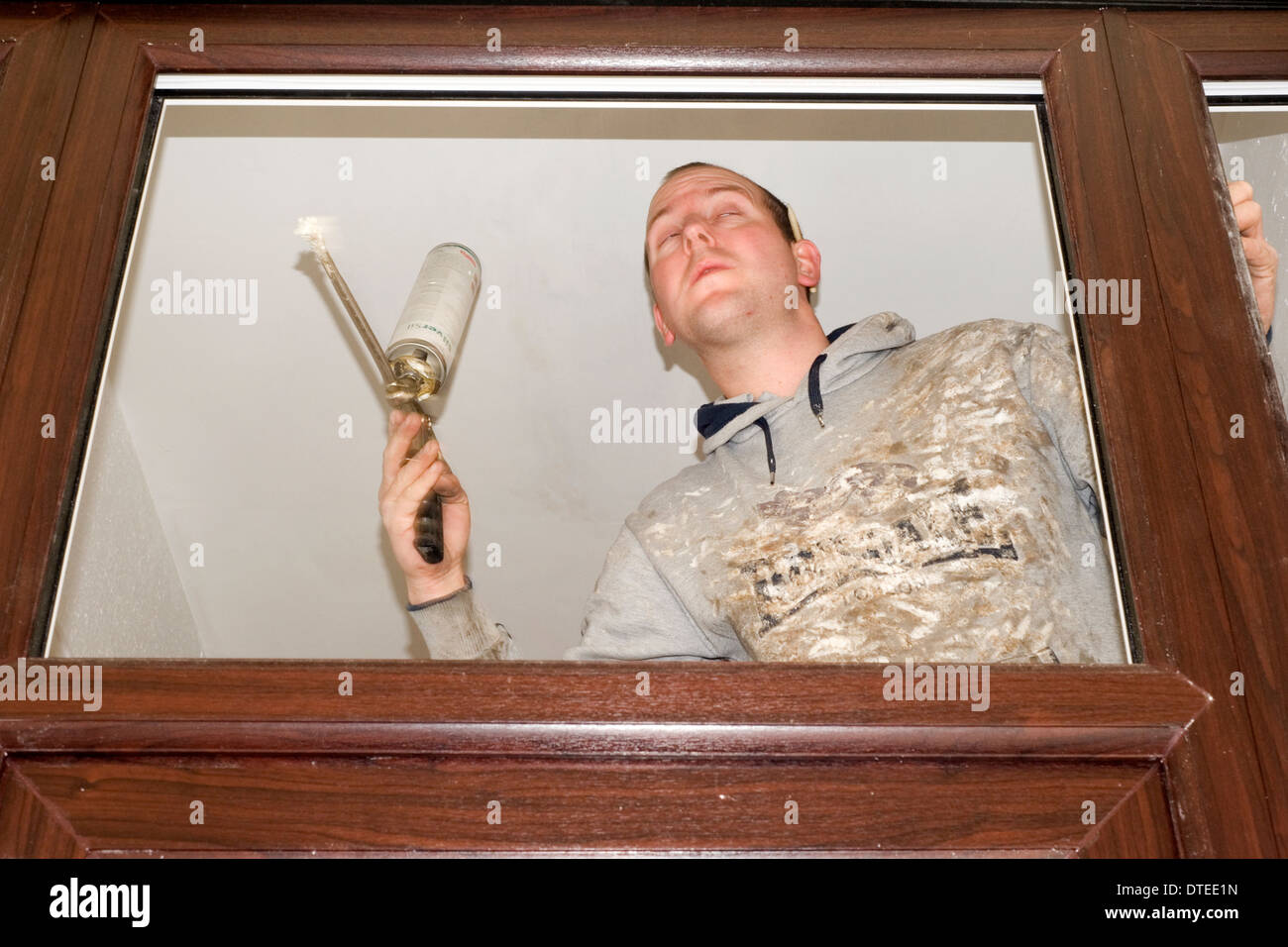 Handwerker bei der Arbeit bereitet eine neue Tür und Zarge für die Montage an der Vorderseite des inländischen Haus Stockfoto