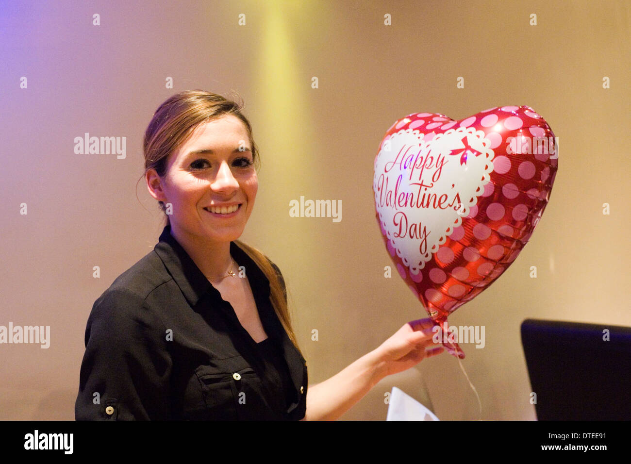junge Frau mit Herz geformten Ballon einen ruhigen romantischen Valentinstag-Abend in einem Restaurant genießen Stockfoto