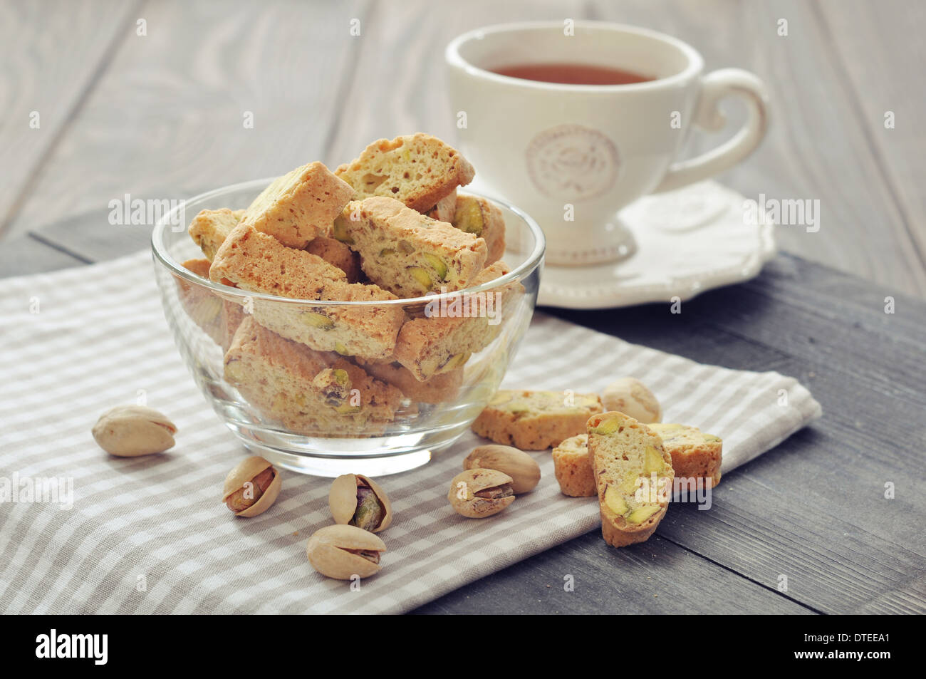 Frische Cantuccini mit Pistazien in Glasschüssel auf hölzernen Hintergrund Stockfoto