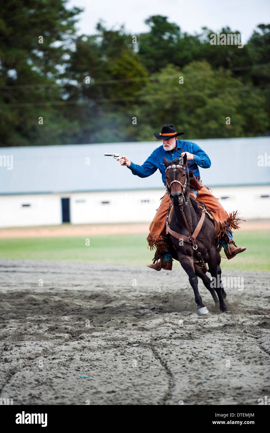 Ein Cowboy auf einem Pferd Reiten in vollem Galopp mit Pistole gezogen. Annie Oakley Boom Tage Festival in Pinehurst, North Carolina. Stockfoto