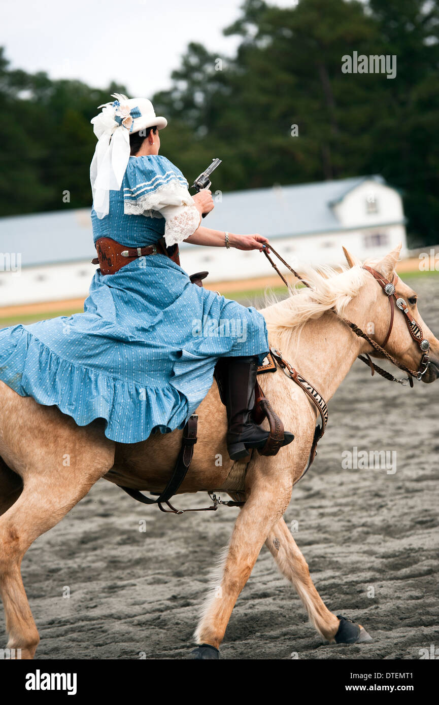 Ein Cowgirl auf einem Pferd Reiten in vollem Galopp mit Pistole gezogen. Annie Oakley Boom Tage Festival in Pinehurst, North Carolina. Stockfoto