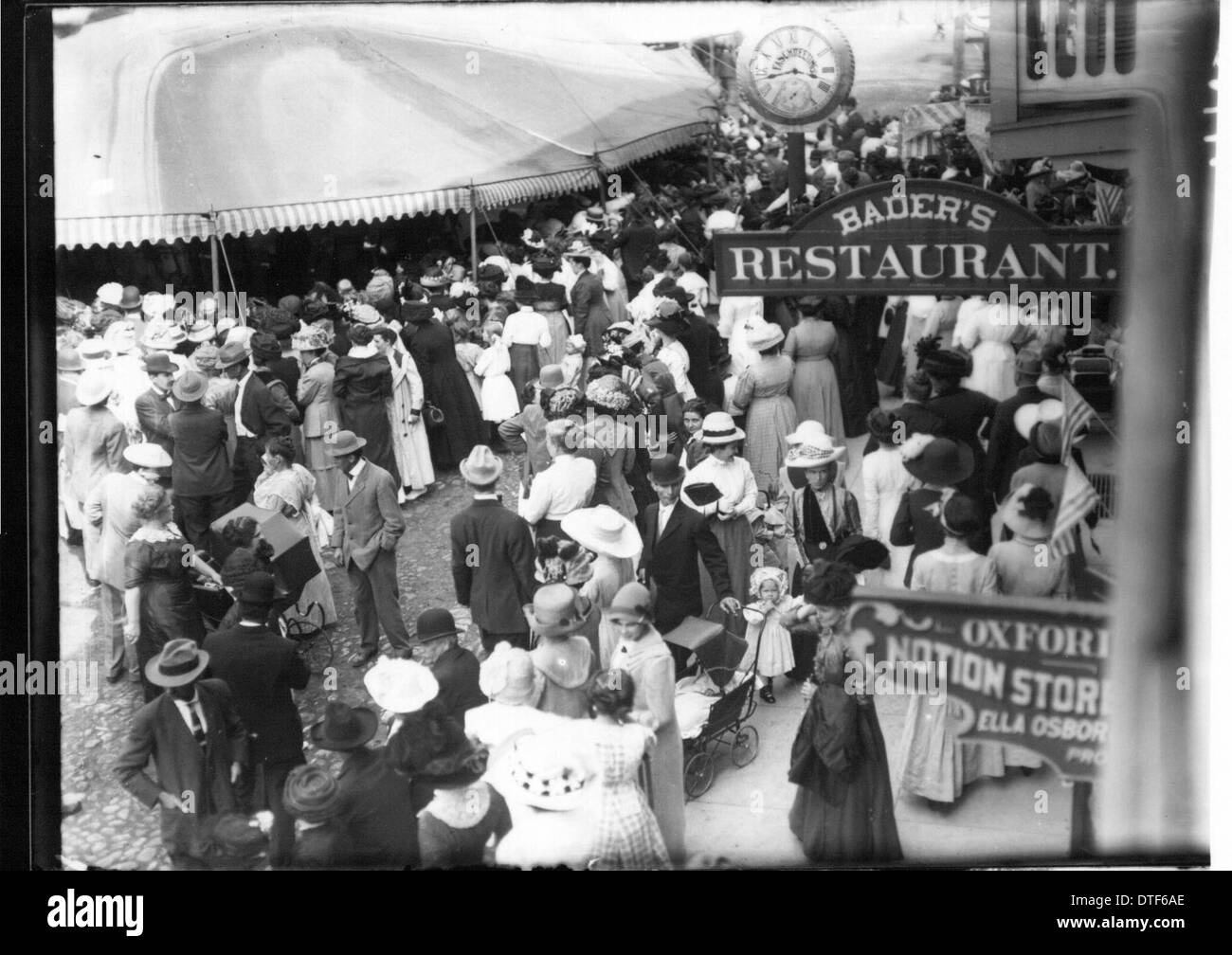 Eine Szene von der Oxford Street Fair im Jahr 1912, die eine geschäftige Menschenmenge von Fußgängern zeigt. Das Foto zeigt das pulsierende Stadtleben, mit Schildern und Stadtuhren, die die historische Atmosphäre der Veranstaltung verstärken. Stockfoto