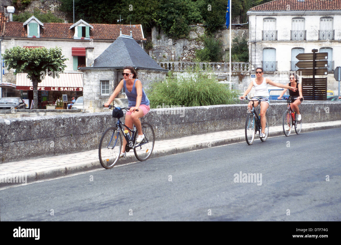 DREI FRAUEN RADFAHREN URLAUB ENTSCHEIDUNGSTRÄGER ÜBER EINE BRÜCKE IN FRANKREICH Stockfoto