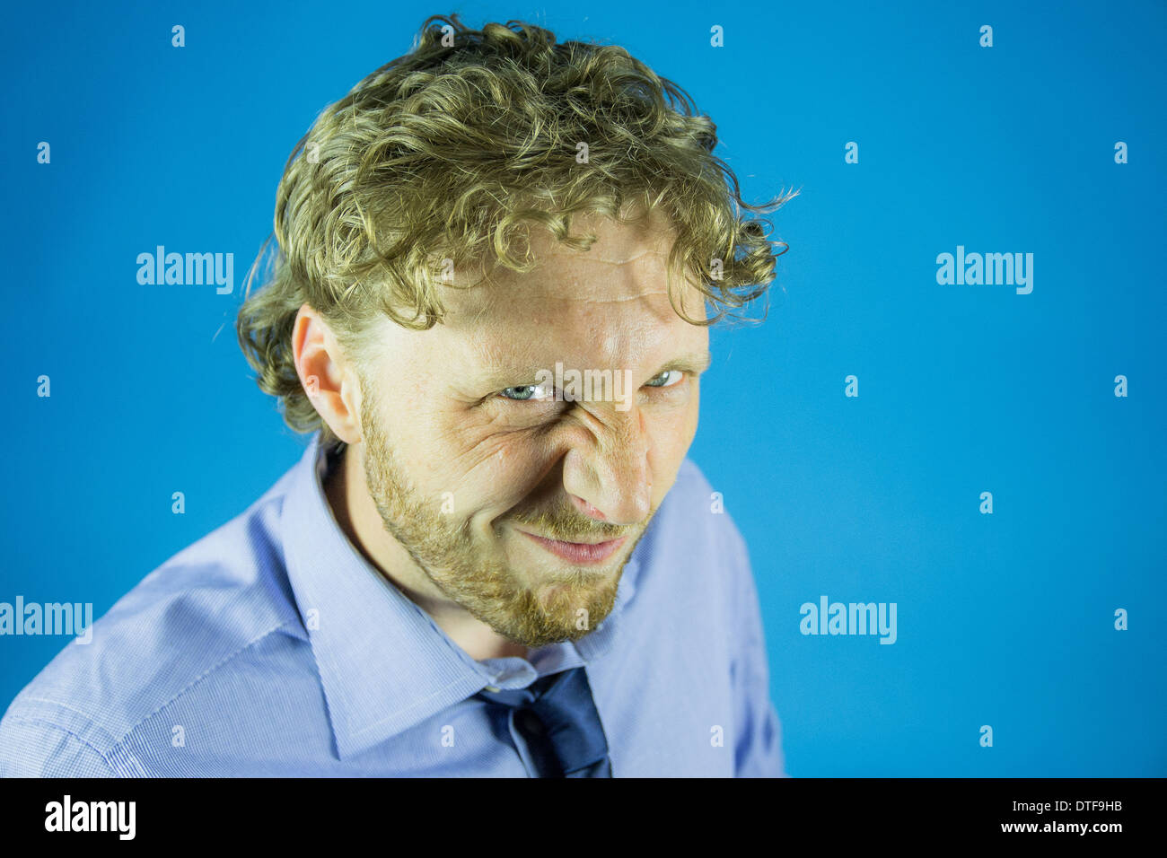 Geschäftsmann mit trotzigen Blick auf blauen Himmelshintergrund Stockfoto