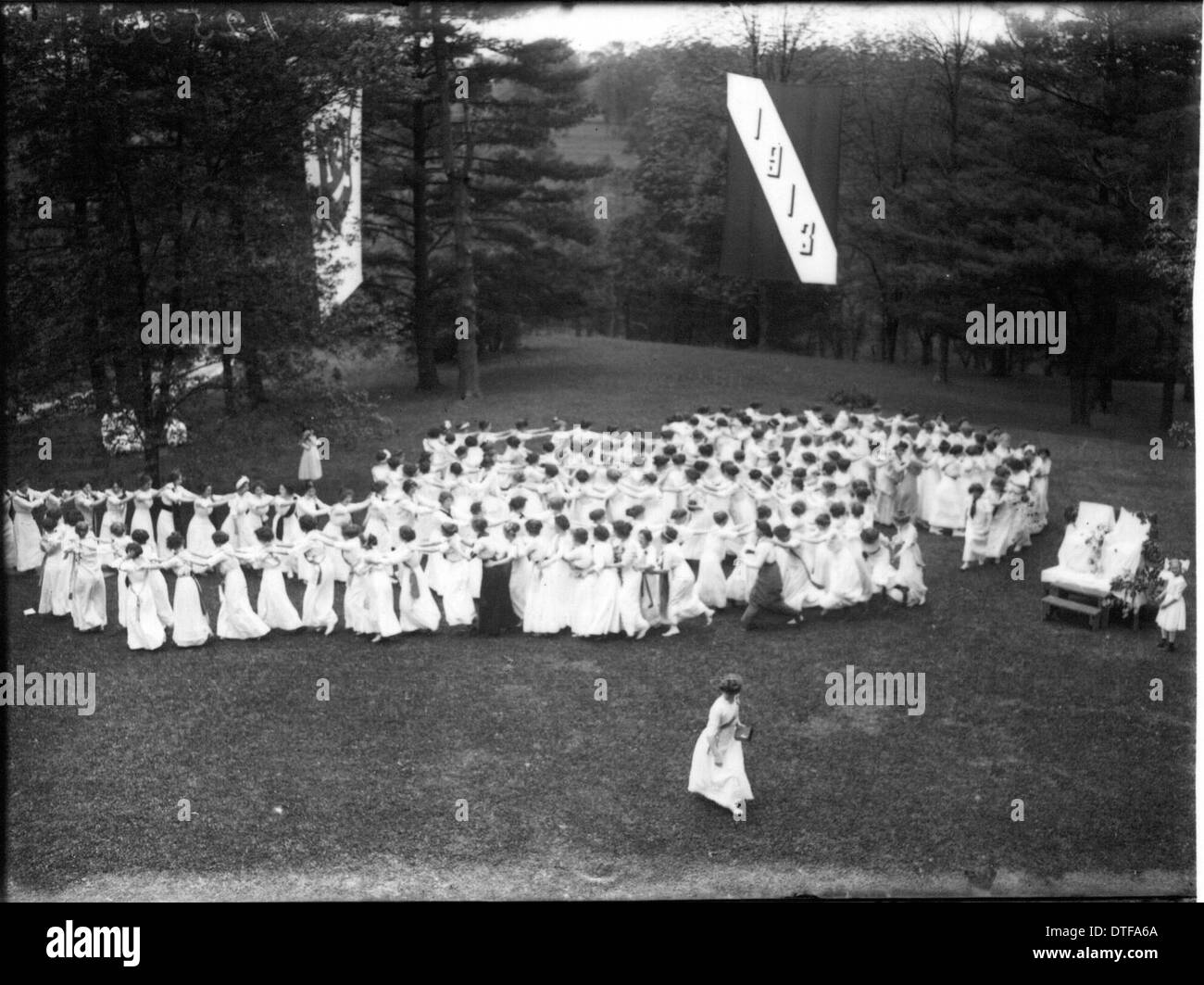 Dieses historische Bild zeigt den Tree Day 1913 am Western College, wo Banner und Open-Air-Theaterproduktionen gezeigt wurden. Die Veranstaltung hob die Rolle der außerschulischen Aktivitäten und der Förderung der Frauenbildung im frühen 20. Jahrhundert hervor und hob die Bedeutung von Gemeindeveranstaltungen im akademischen Leben hervor. Stockfoto