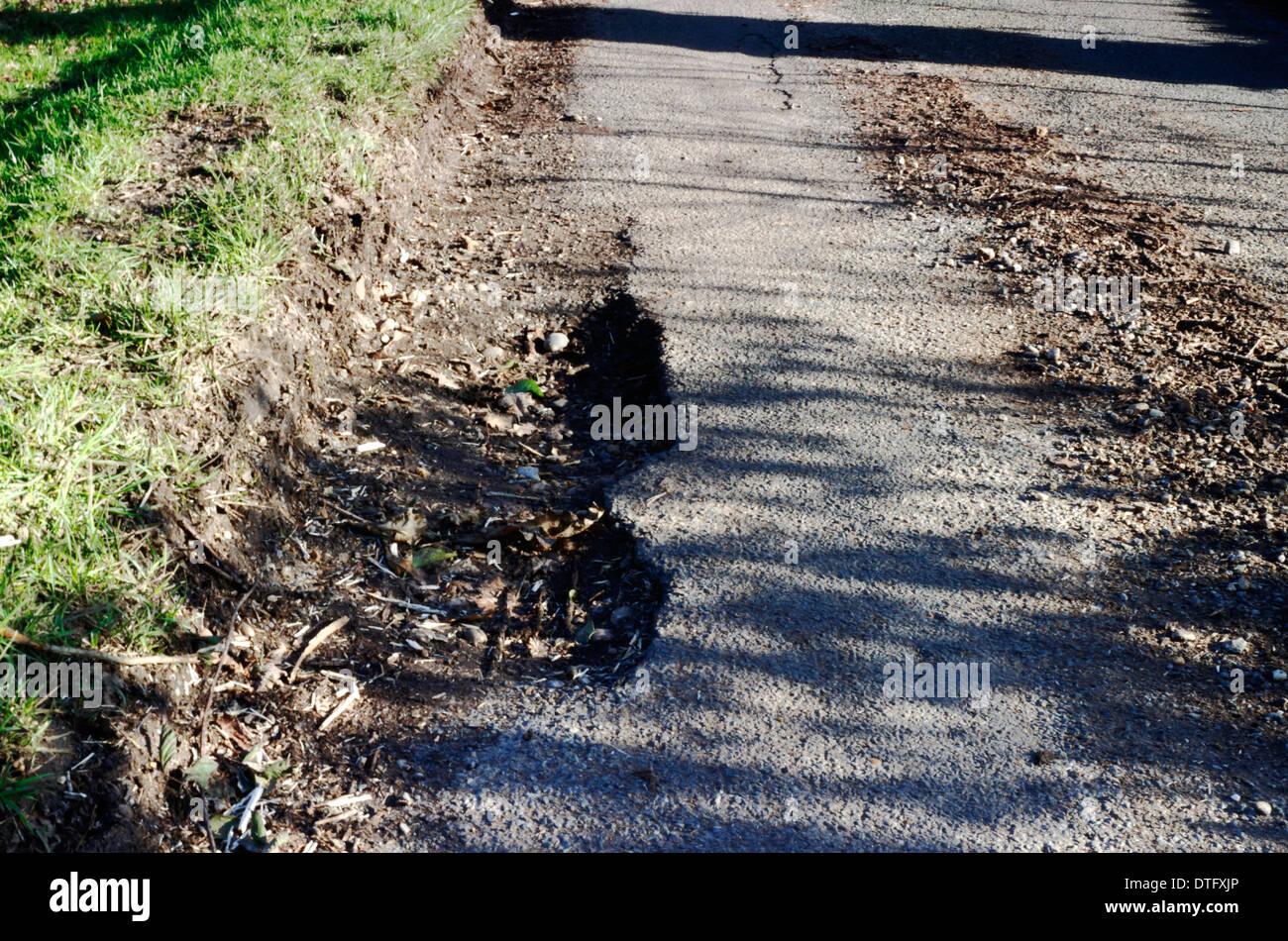 Schlaglöcher auf den Rand des einen eine Landstraße im ländlichen Norfolk, England, United Kingdom. Stockfoto