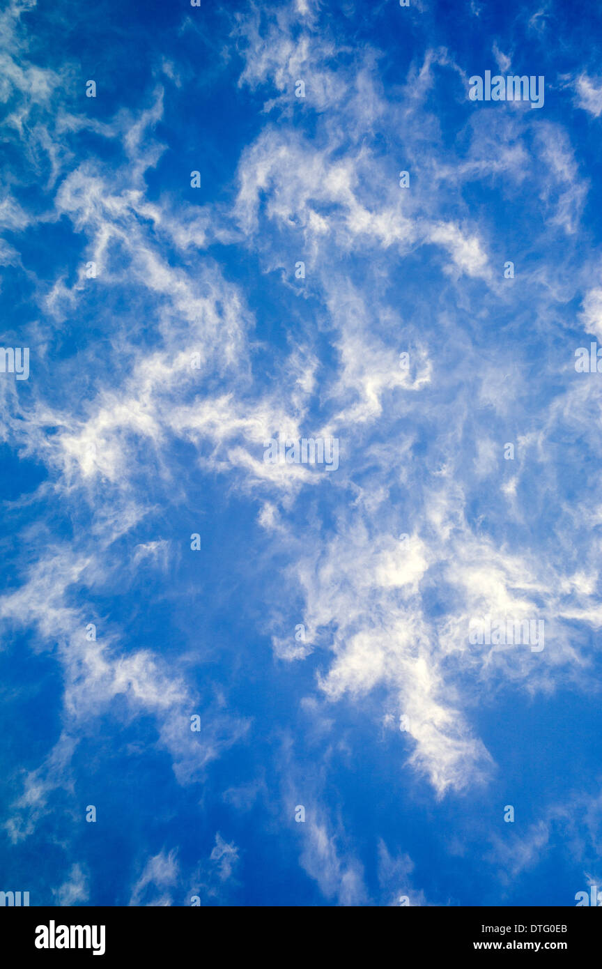 Weiße Wolkenfetzen vor einem strahlend blauen Himmel Stockfoto