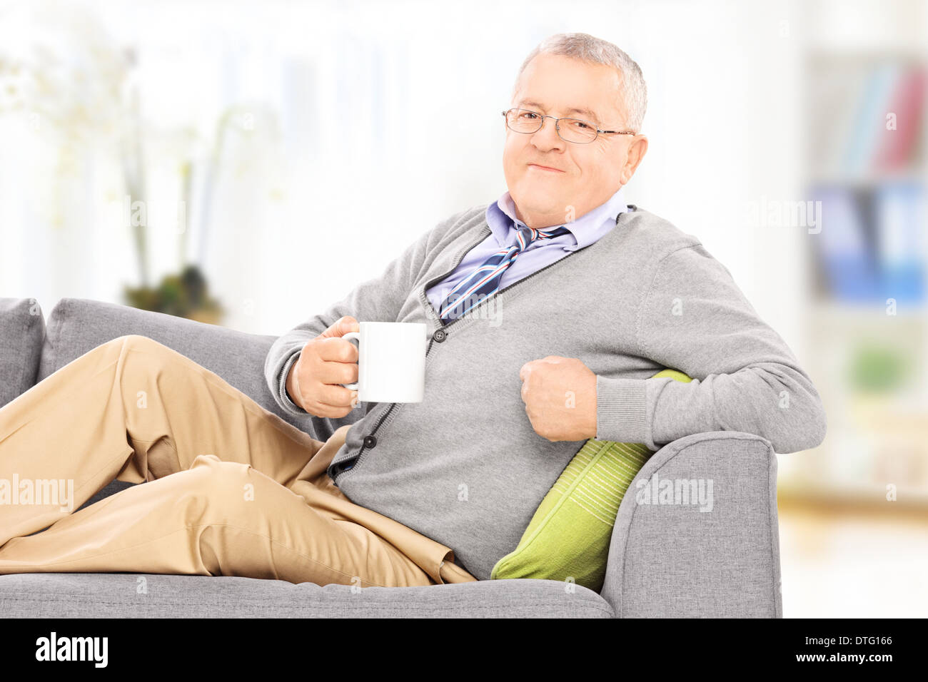 Entspannte Gentleman Verlegung auf Sofa und tranken Kaffee, drinnen Stockfoto