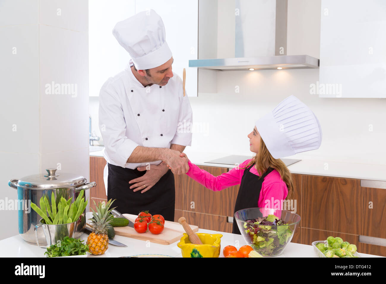 Chef Master und Junior Schüler Kind Mädchen Handshake bei Kochschule Stockfoto