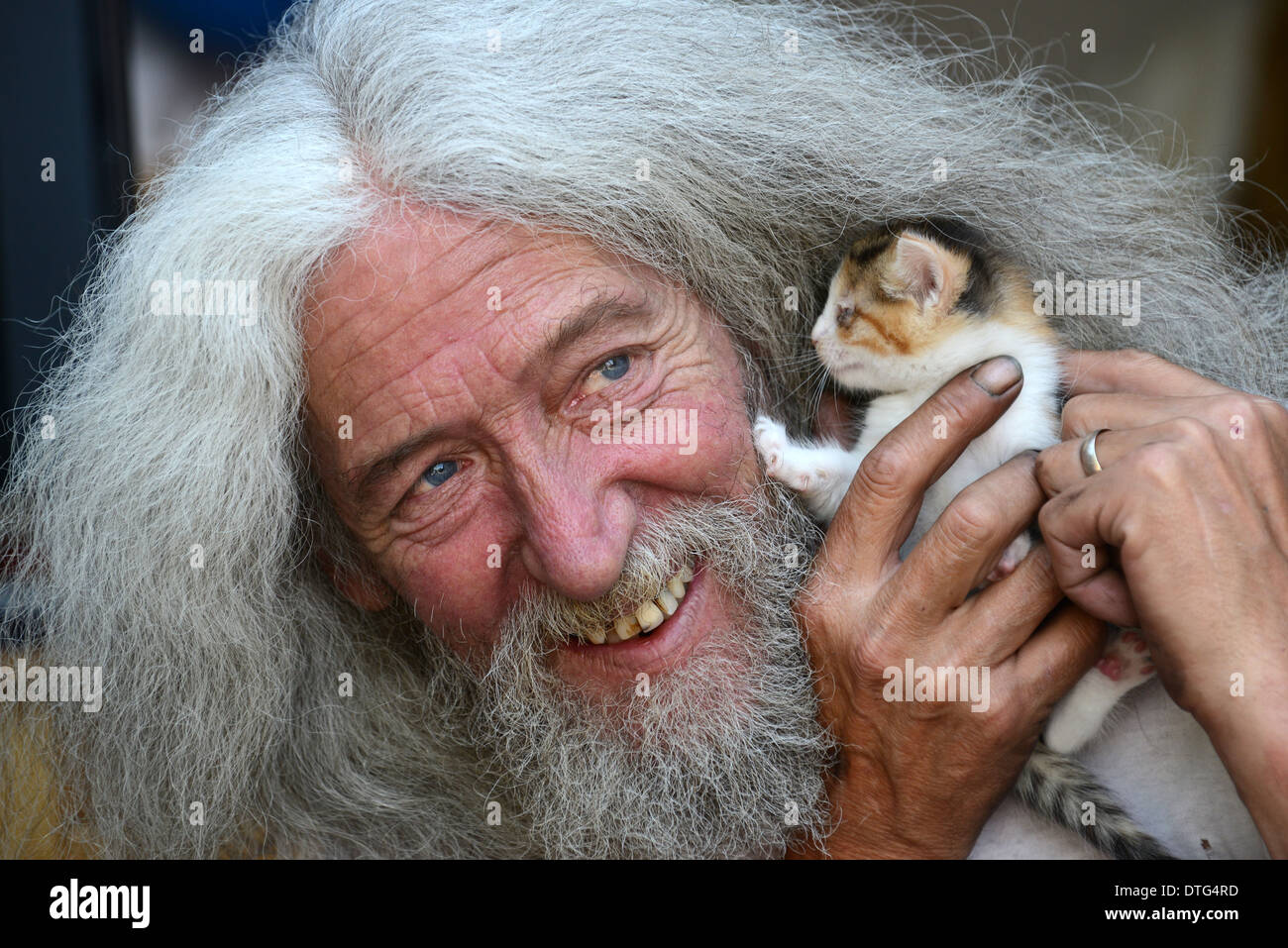 Mann mit langen Haaren und Bart John Julian mit einem der Kätzchen, die er in seinem Schuppen gefunden. Freundliche Tierliebhaber Kätzchen retten Großbritannien Menschen männlich gerettet Stockfoto