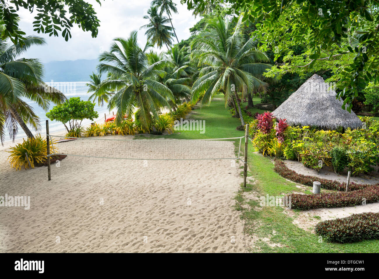 Ein Beachvolleyball-Platz in einem üppigen, exotischen tropischen Resort von Ozean und gesunde grüne Bäume und Gärten gesäumt. Stockfoto