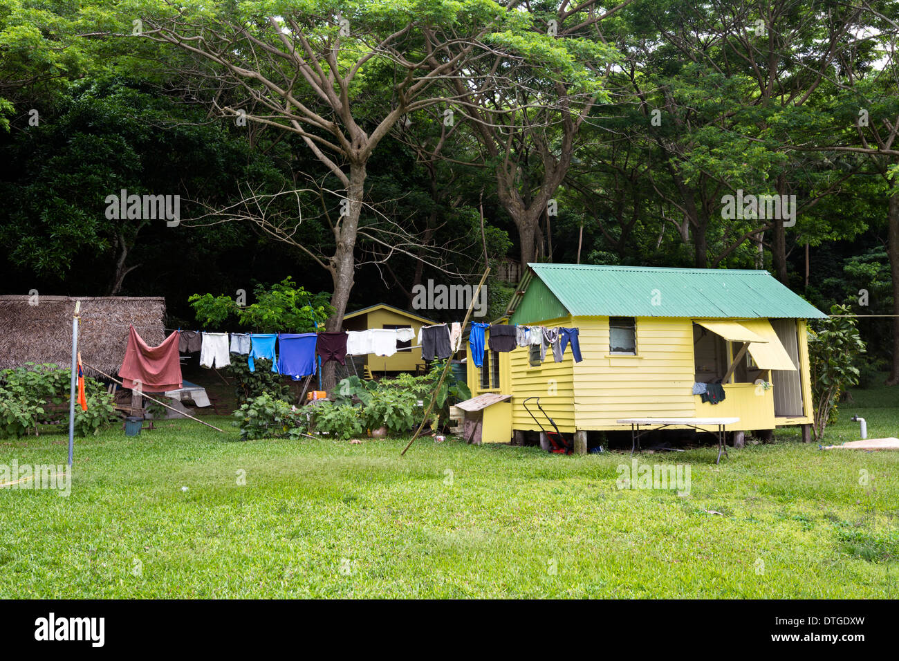 Eine Fernbedienung gelb Hütte in der Nähe der Basis des Regenwaldes mit Wäsche trocknen im Wind. Stockfoto