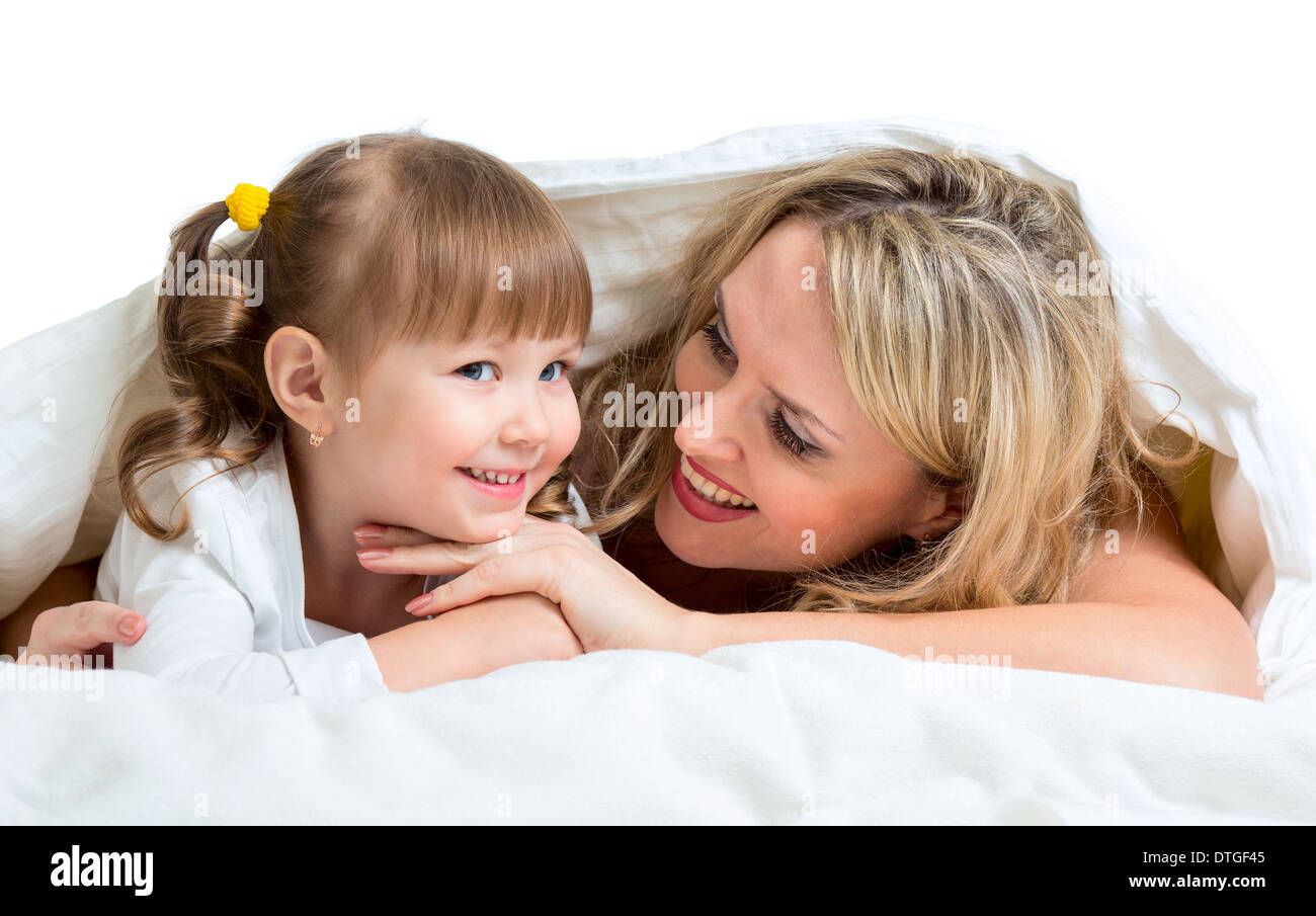 Lächelnde Mutter und Kind liegen unter der Decke Stockfoto