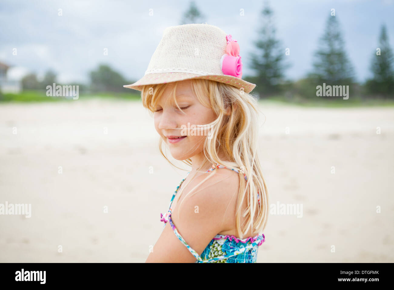 Porträt von glücklich süße junge Mädchen mit stylischen Hut am Strand mit geschlossenen Augen Stockfoto